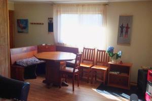 d'un salon avec une table, des chaises et une fenêtre. dans l'établissement Chalet Valdivia, à Valdivia