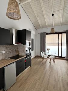 a kitchen and dining room with a table and chairs at M&M Empedrada Apartamentos Jerez in Jerez de la Frontera