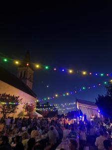 a crowd of people sitting at tables at night at Château Neuf Le Désert in Le Pizou