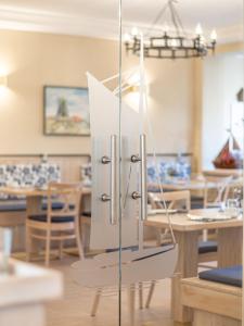 a kitchen and dining room with a refrigerator at Hotel Stone in Zingst