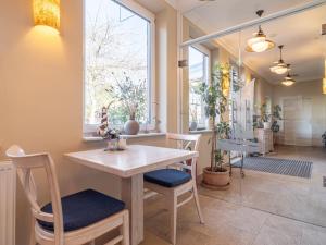 a dining room with a table and chairs and a window at Hotel Stone in Zingst