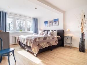 a bedroom with a bed and two windows at Hotel Stone in Zingst