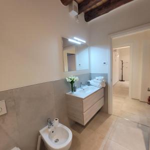ein Badezimmer mit einem Waschbecken, einem WC und einem Spiegel in der Unterkunft Angelo&Marì Mountain Lake Iseo Hospitality in Marone