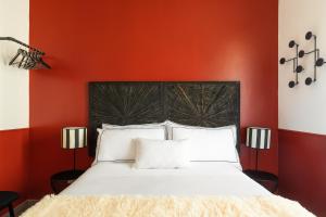 a bedroom with red walls and a bed with white pillows at Cozy apartment Gianicolense 3bdr in Rome +57 photos