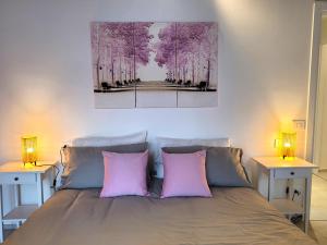 a bedroom with a bed with two pink pillows at Angelo&Marì Mountain Lake Iseo Hospitality in Marone