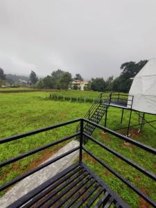 a metal bench in a field with a tent at Croft Yelagiri - glamping stay in Yelagiri
