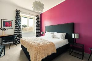a bedroom with a large bed with a pink wall at Cozy apartment Gianicolense 3bdr in Rome