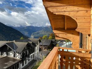 a wooden balcony with a view of mountains at Chalet L'Adret, 3,5 pièces dans les combles. in Gryon