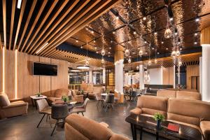 a lobby with couches and chairs and a tv at Park & Spa Hotel Markovo in Plovdiv
