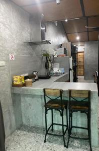 dwa krzesła siedzące przy blacie w kuchni w obiekcie แครินโฮมสเตร์ w mieście Koh Lone