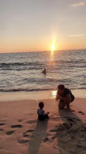 two teddy bears sitting in the sand on the beach at แครินโฮมสเตร์ in Koh Lone