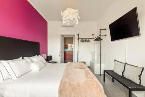 a bedroom with a white bed and a pink wall at Cozy apartment Gianicolense 3bdr in Rome