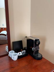 a coffee maker and two cups on a wooden floor at Union Hotel Prague in Prague