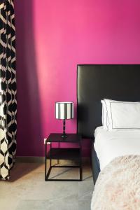 a bedroom with a pink wall and a table with a lamp at Cozy apartment Gianicolense 3bdr in Rome