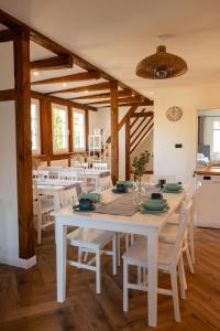 uma sala de jantar com uma mesa branca e cadeiras em Osada Mazurowe Love em Miłakowo