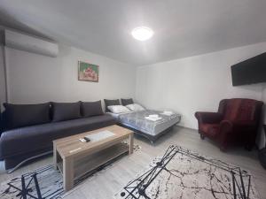 uma sala de estar com um sofá e uma mesa de centro em Cuprija _apartments em Stolac