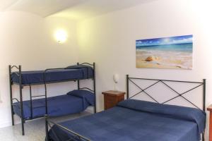 Bed & Bike Casa dei Papi في بورتوفيرّايو: غرفة نوم مع سريرين بطابقين وكلب على الشاطئ