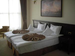 Habitación de hotel con 2 camas y toallas. en Hotel Rexton en Craiova