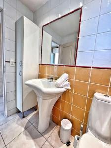 uma casa de banho com um lavatório, um espelho e um WC. em Sanary, Vue mer à petit prix, plage à pieds em Sanary-sur-Mer