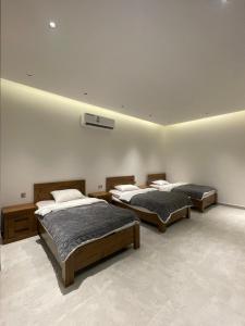 Habitación con 3 camas en una habitación en النوف فيلا, en Murayjāt