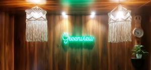 two chandeliers and a neon sign on a wall at Greenview holiday inn in Munnar