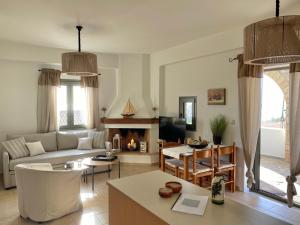 sala de estar con sofá y chimenea en Horizon Villa Mani - Seaview Family Friendly House, en Stoupa