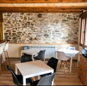 um restaurante com mesas e cadeiras e uma parede de pedra em Hotel Rural El Rincón de Marta em Yanguas