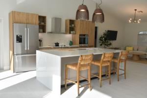 a kitchen with a large island with bar stools at Luxury contemporary hidden gem in Lehigh Acres