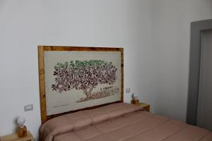 1 dormitorio con una foto de un árbol en la pared en Suites Cavallotti Il Carrubo, en Orvieto