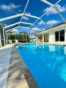 a large swimming pool with blue water at Luxury contemporary hidden gem in Lehigh Acres