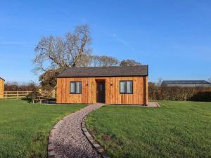 uma pequena casa de madeira no meio de um campo em Walnut Lodge em Ashbourne