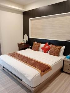 1 dormitorio con 1 cama blanca grande con almohadas rojas en 金富有民宿, en Chishang
