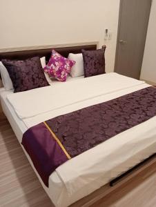 池上鄉的住宿－金富有民宿，一张配有紫色和白色床单及枕头的大床