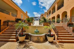 a building with stairs and potted plants in a courtyard at Luxury Banus Puerto Golf in Marbella