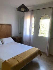 a bedroom with a white bed and two windows at Luxury Banus Puerto Golf in Marbella +19 photos