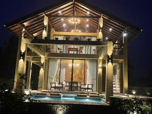 a house with a pool in front of it at night at The Villa Lakeshore in Anuradhapura