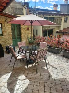 un tavolo e sedie con ombrellone su un patio di La Casa nel Borgo a Bergamo