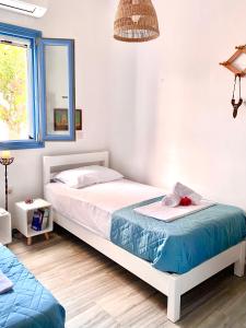 a bedroom with a white bed and a mirror at Elitas Lodge: Cosy Cycladic home outside Paroikia in Kampos Paros