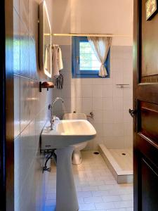 a white bathroom with a sink and a toilet at Elitas Lodge: Cosy Cycladic home outside Paroikia in Kampos Paros