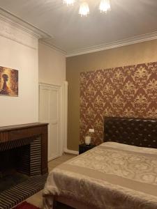 1 dormitorio con 1 cama y chimenea en GERS -Midi-Pyrénées -Appartement 2chambres, en Castelnau-dʼAuzan