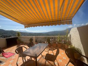 um pátio com uma mesa e cadeiras numa varanda em Mina House em Chefchaouen