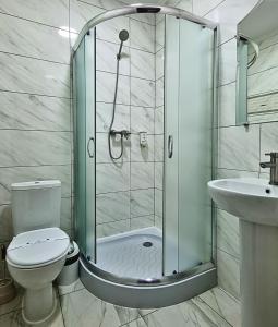 e bagno con doccia, servizi igienici e lavandino. di Готель "Валерія" a Novoselytsya