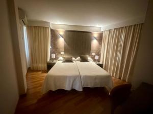 1 dormitorio con 1 cama con sábanas y cortinas blancas en Hotel Costamar, en Morche