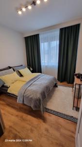 a bedroom with a large bed with green curtains at Nico's stylish Apartment in Satu Mare