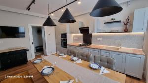 a kitchen with a dining table and a kitchen with black lights at Nico's stylish Apartment in Satu Mare