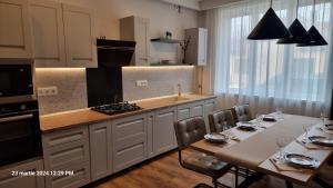 a kitchen with a table and two tables and a stove at Nico's stylish Apartment in Satu Mare +15 photos