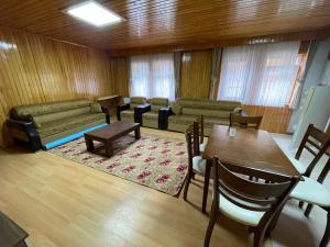 a living room with a table and a couch at Uzungöl Bikka Pansiyon in Uzungöl