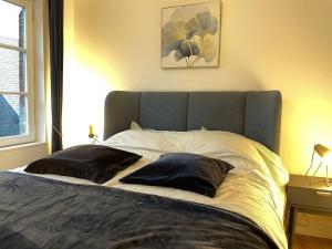 a bed with two pillows on it in a bedroom at Jolie maison centre historique in Honfleur