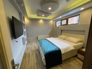 a bedroom with a bed and a flat screen tv at Uzungöl Bikka Pansiyon in Uzungöl +34 photos