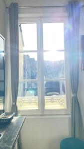 a window in a room with a laptop on a desk at Jolie maison centre historique in Honfleur